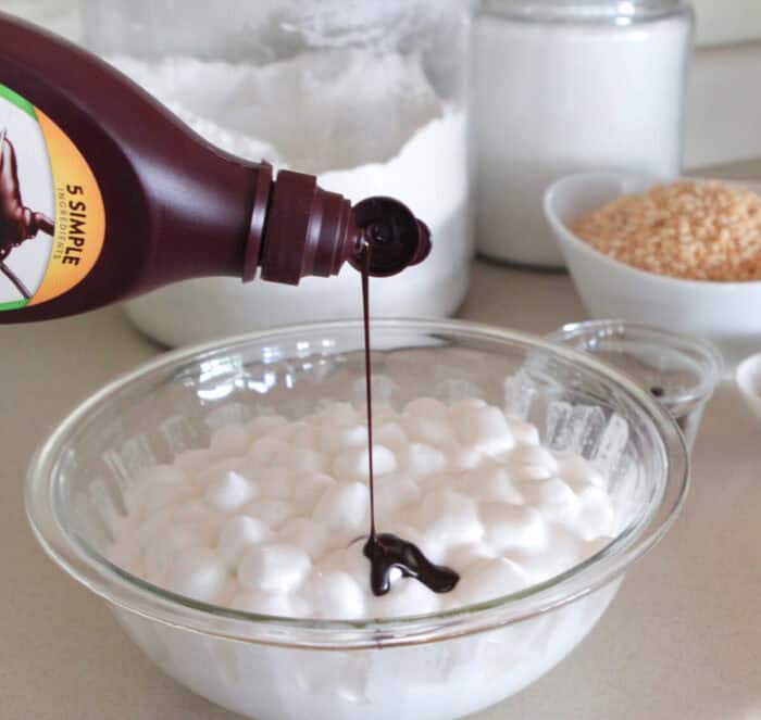 pouring chocolate sauce into melted marshmallows