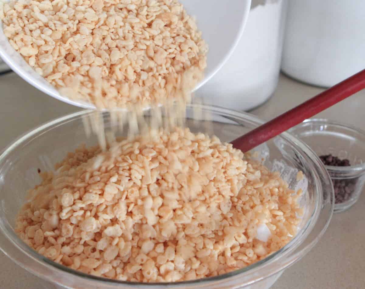 Pouring rice krispie cereal into melted marshmallows