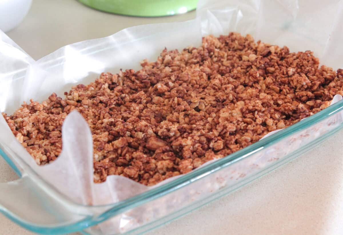chocolate rice krispie treats pressed into baking dish to cool