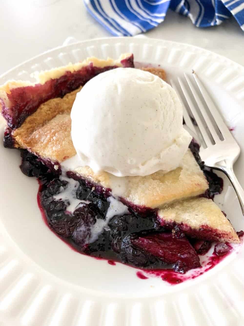 blueberry pie on serving plate with ice cream on top