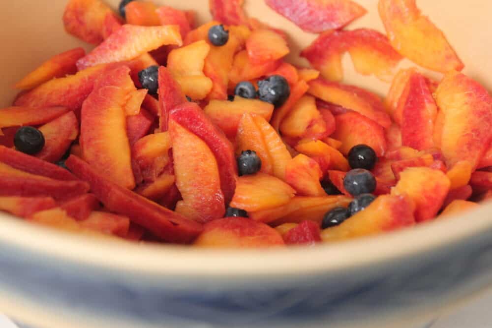 sliced peaches and blueberries in bowl