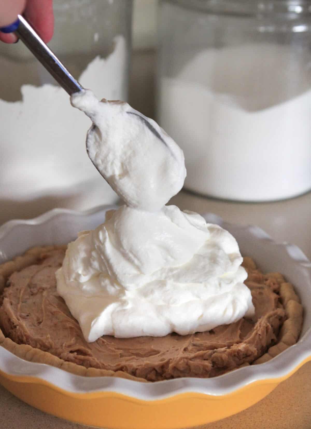 Adding whipped cream to top of pie