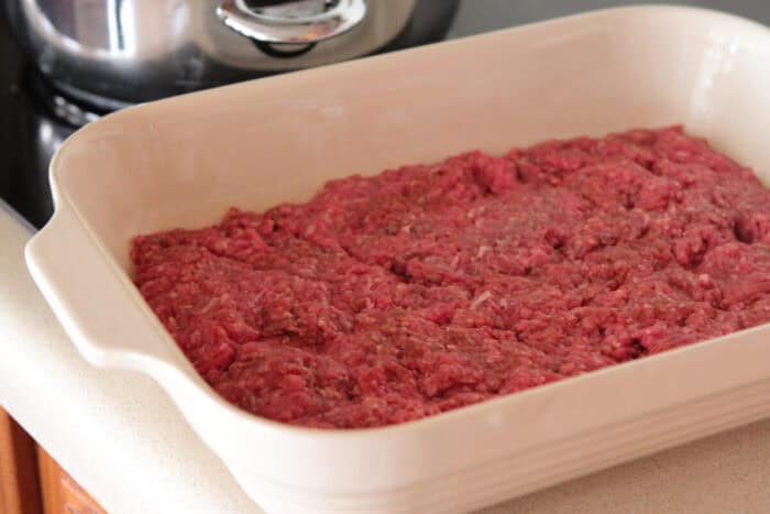 ground beef pressed into bottom of baking dish