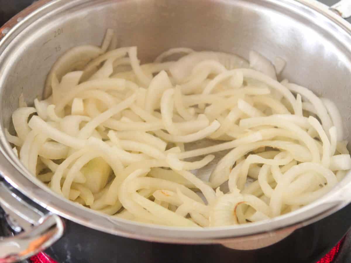 cooking sliced onions in pan