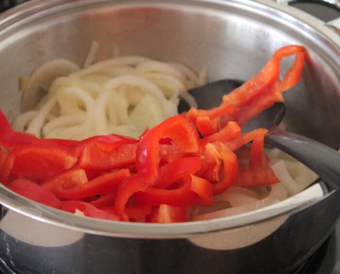 cooking red bell peppers in pan for baked sliders