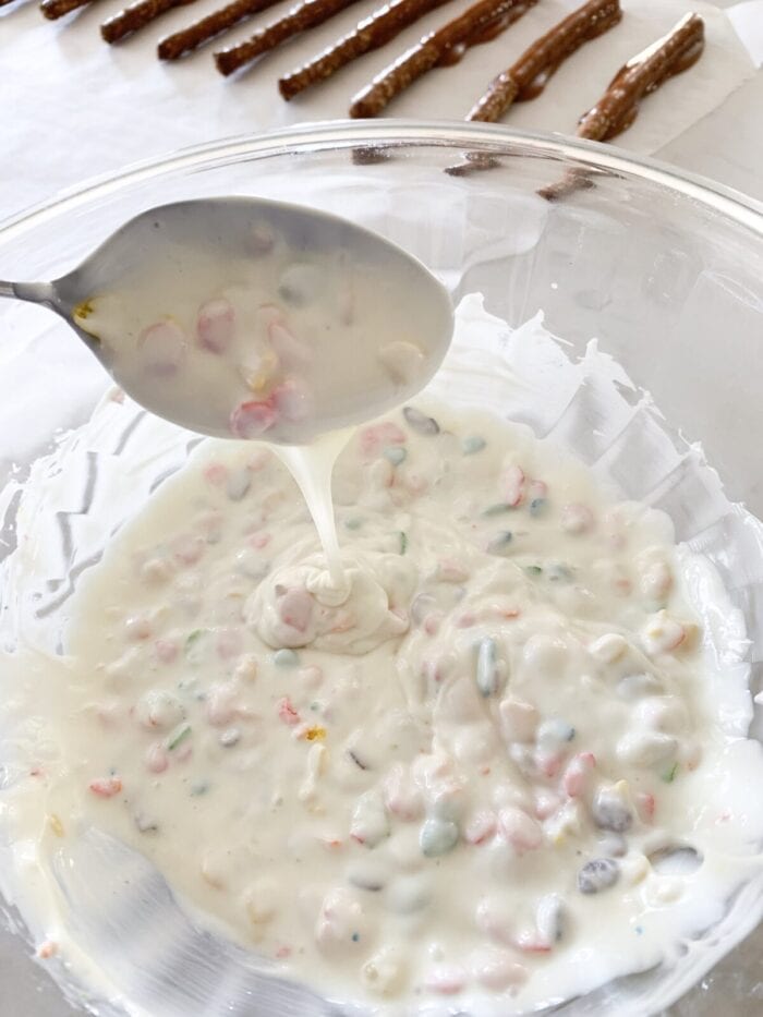 stirring melted white chocolate and fruity pebbles