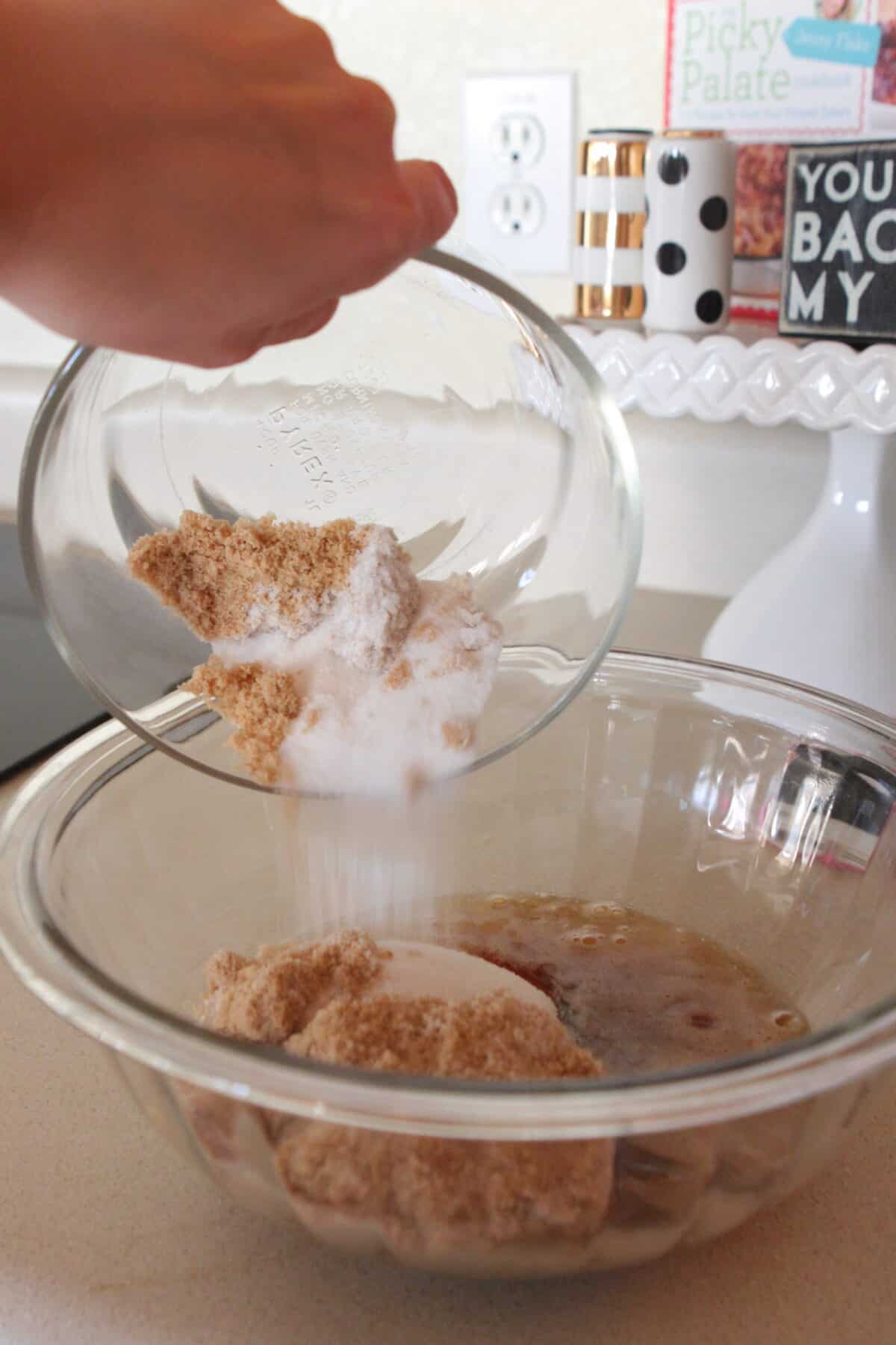pouring sugars into mixing bowl for cinnamon cookies