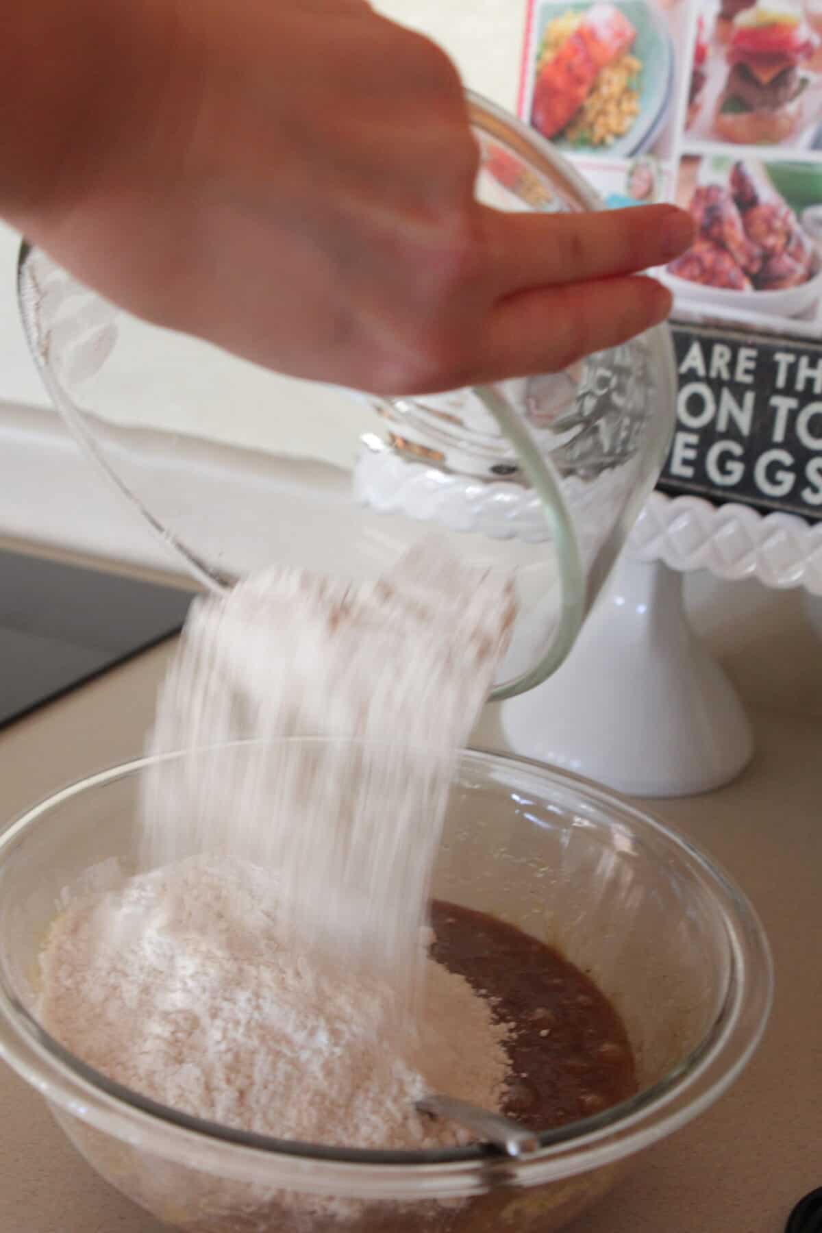 adding flour to mixing bowl for cinnamon cookies