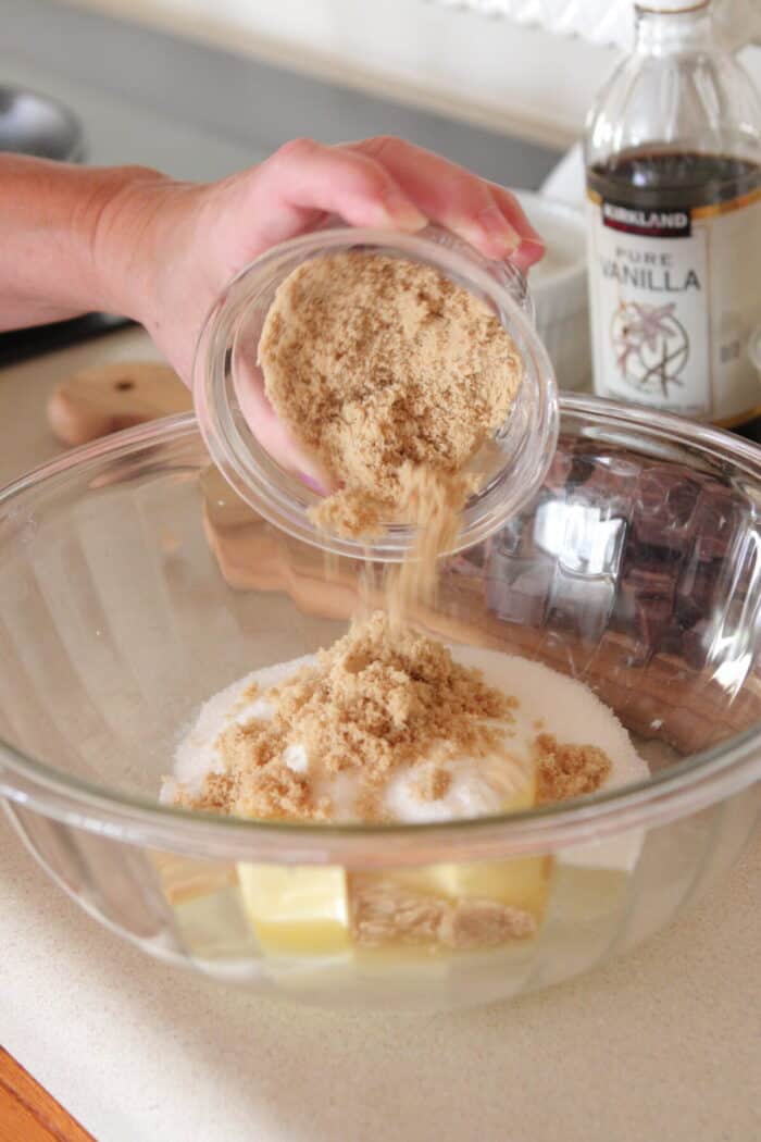 adding brown sugar to mixing bowl for skillet cookie