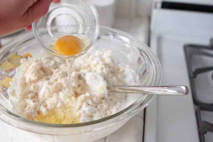 pouring egg in mixing bowl with cake mix