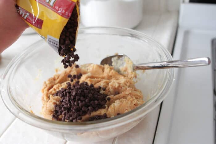 pouring chocolate chips into cake mix dough