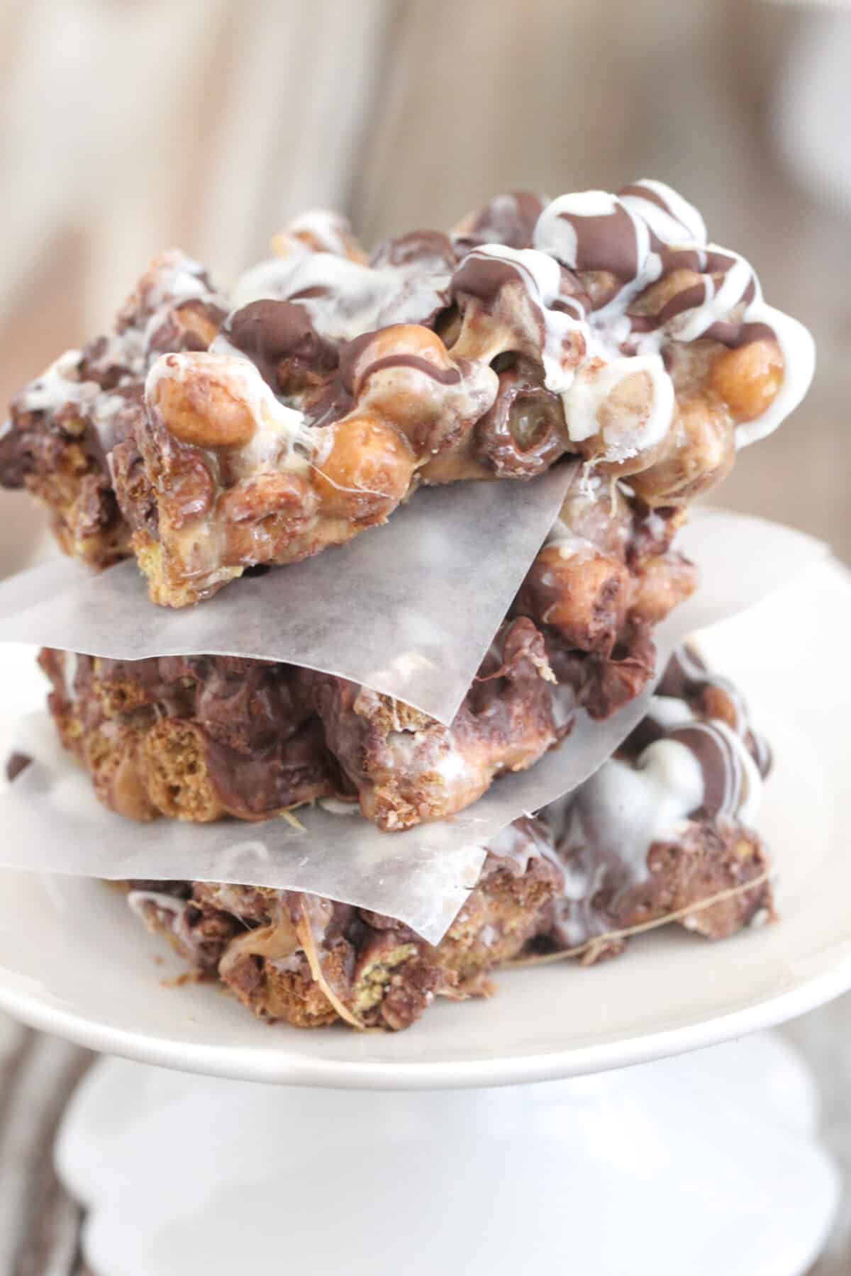 peanut butter crunch bars stacked on a cake plate