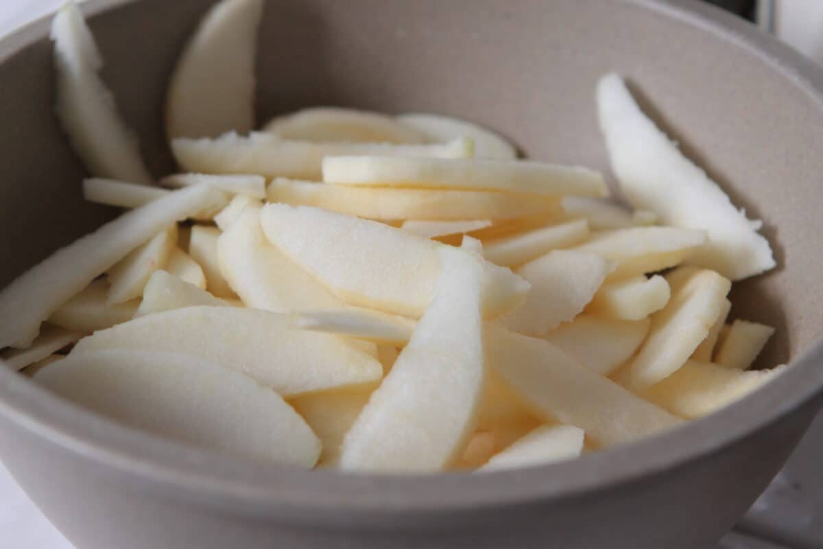 sliced apples in mixing bowl