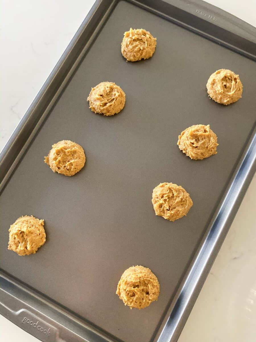 scooping dough onto baking sheet of soft pumpkin cookies
