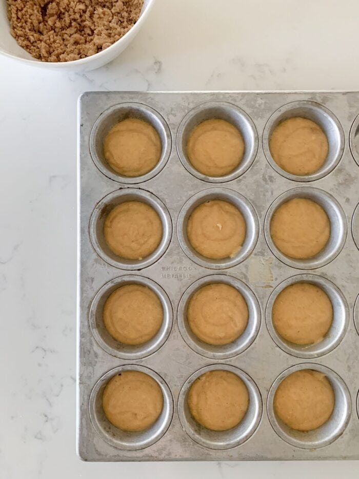 muffin tin filled with pumpkin muffin batter