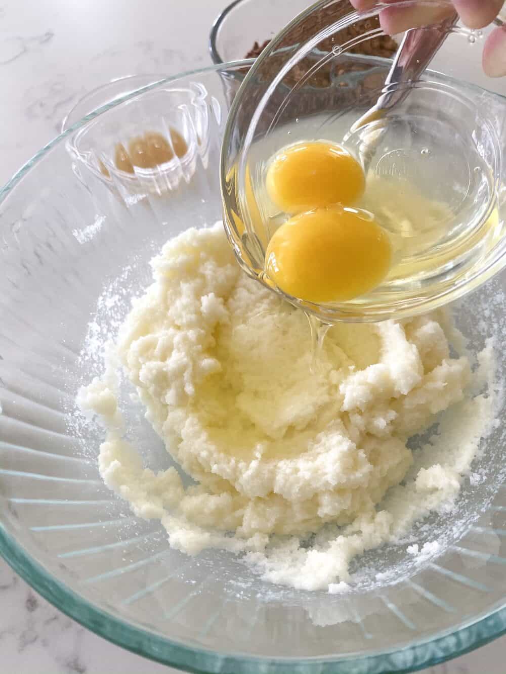 adding eggs to bowl for homemade brownies