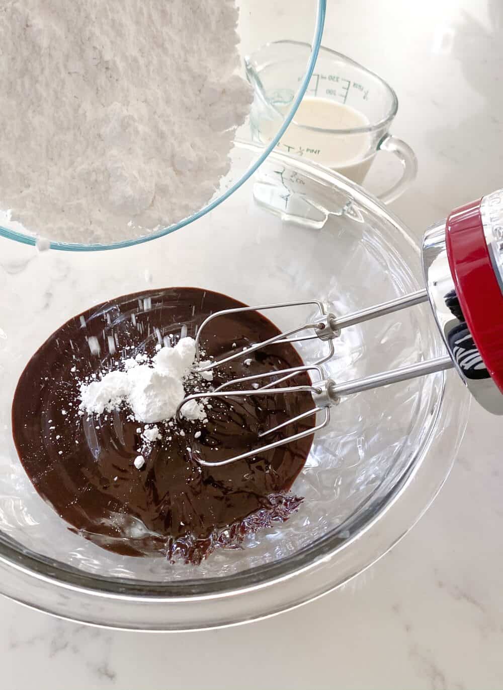 adding powdered sugar to homemade chocolate frosting