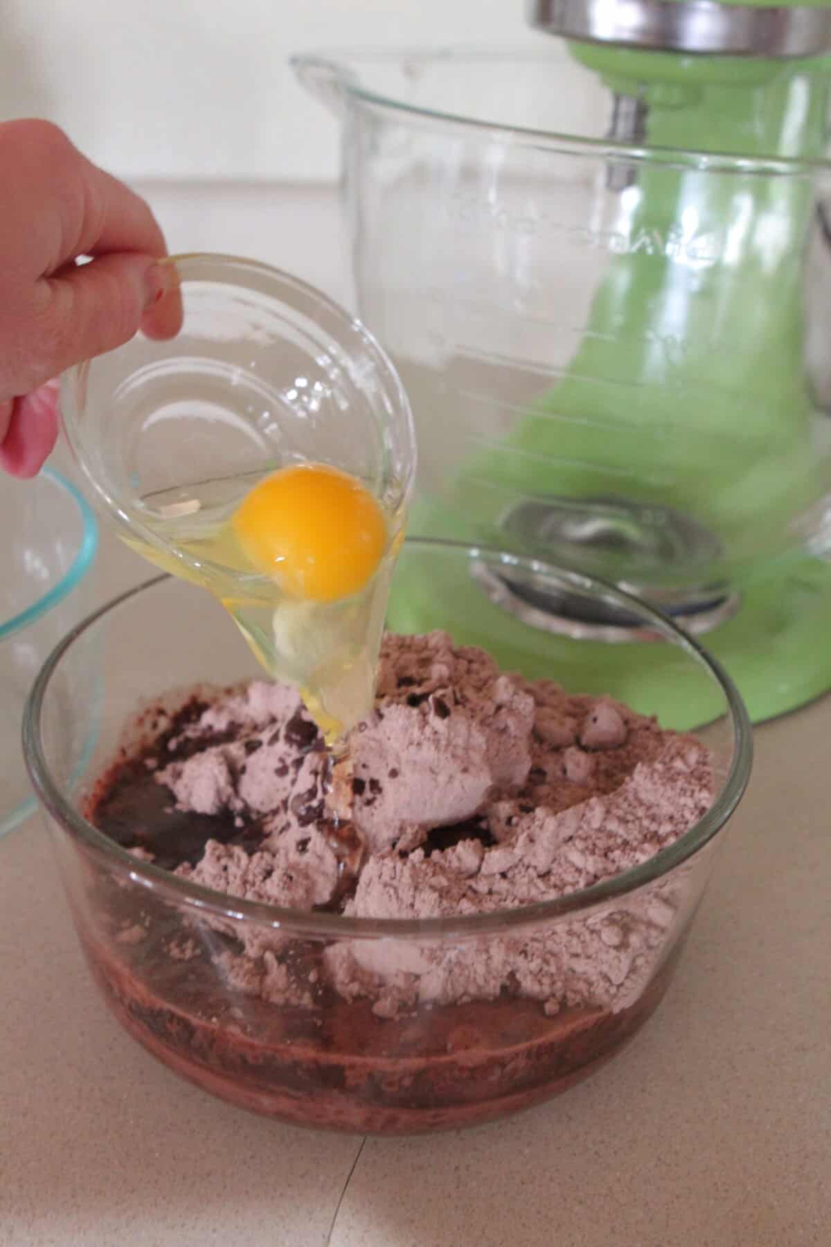 pouring egg into brownie batter bowl