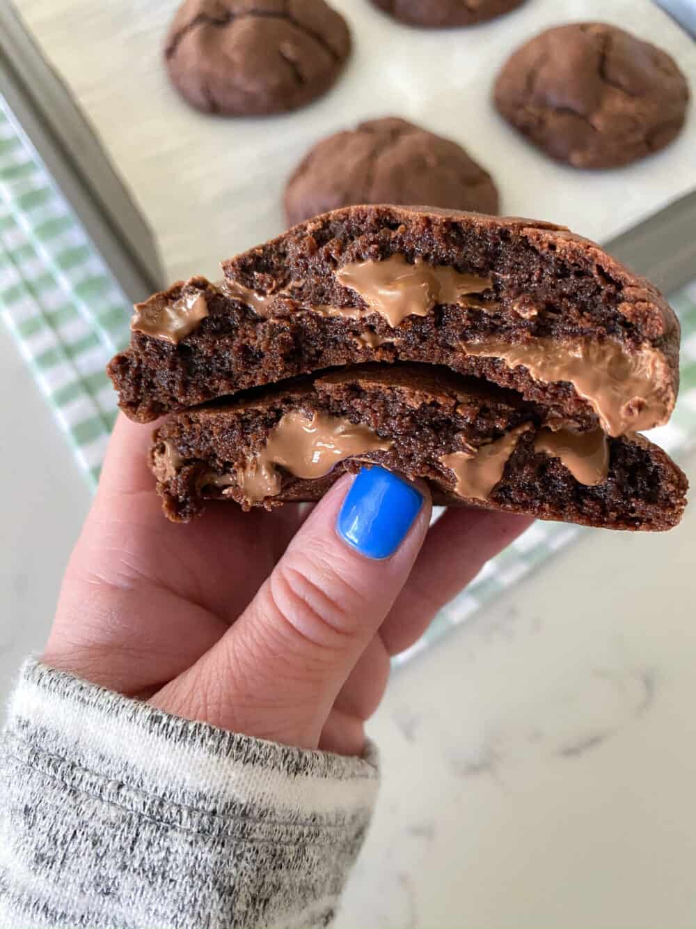 holding double chocolate chip cookies cut in half