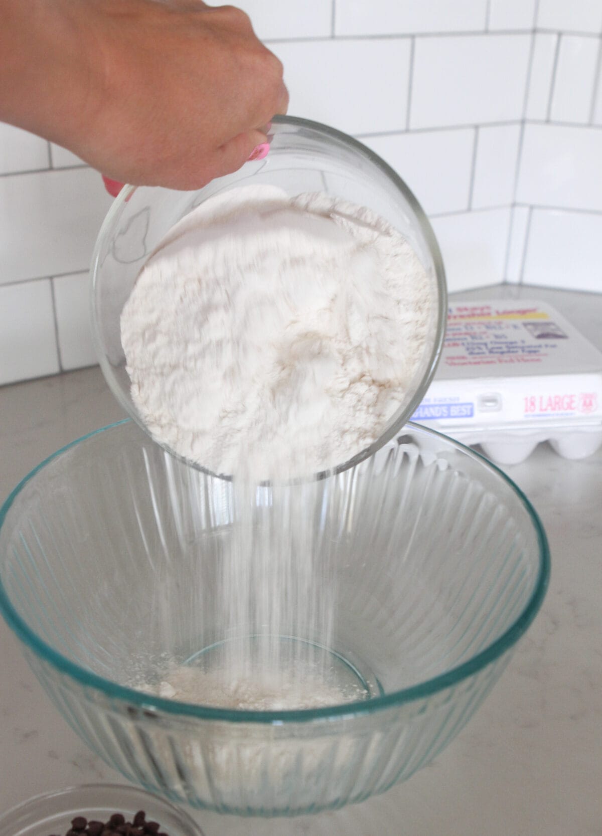 pouring flour into mixing bowl for chocolate chip pancakes