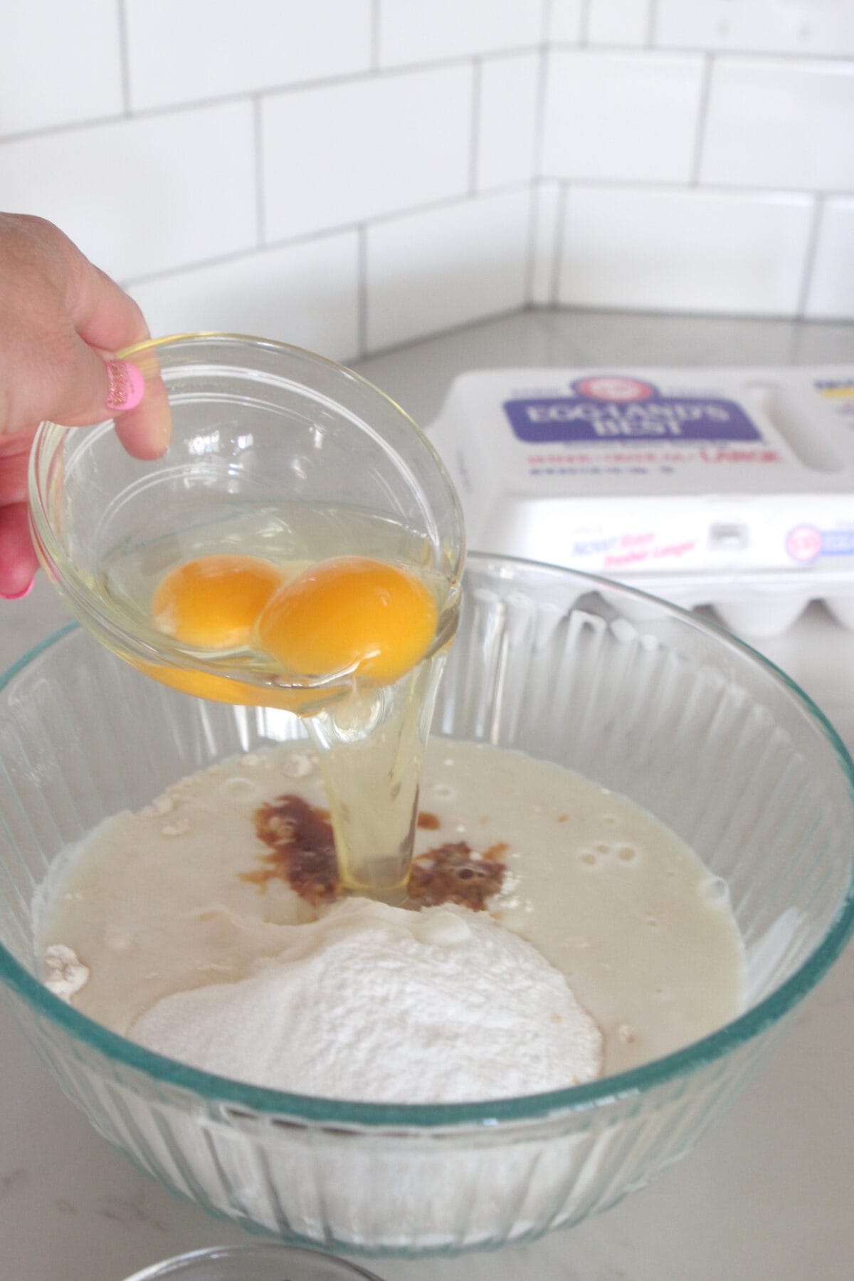 pouring eggs into mixing bowl for homemade pancakes
