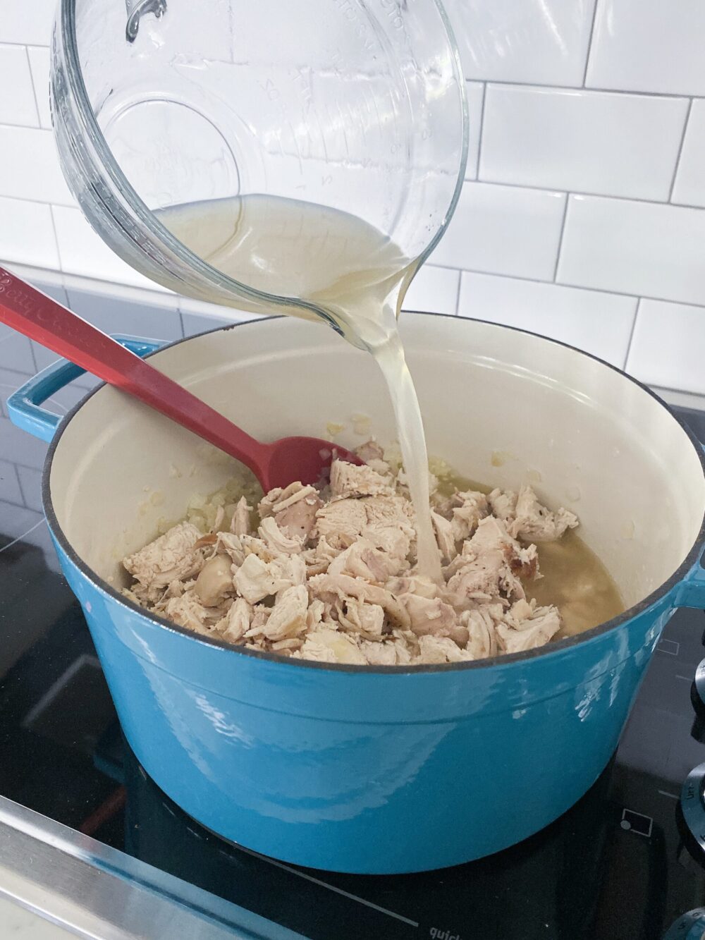 adding chicken broth to white chicken chili pot
