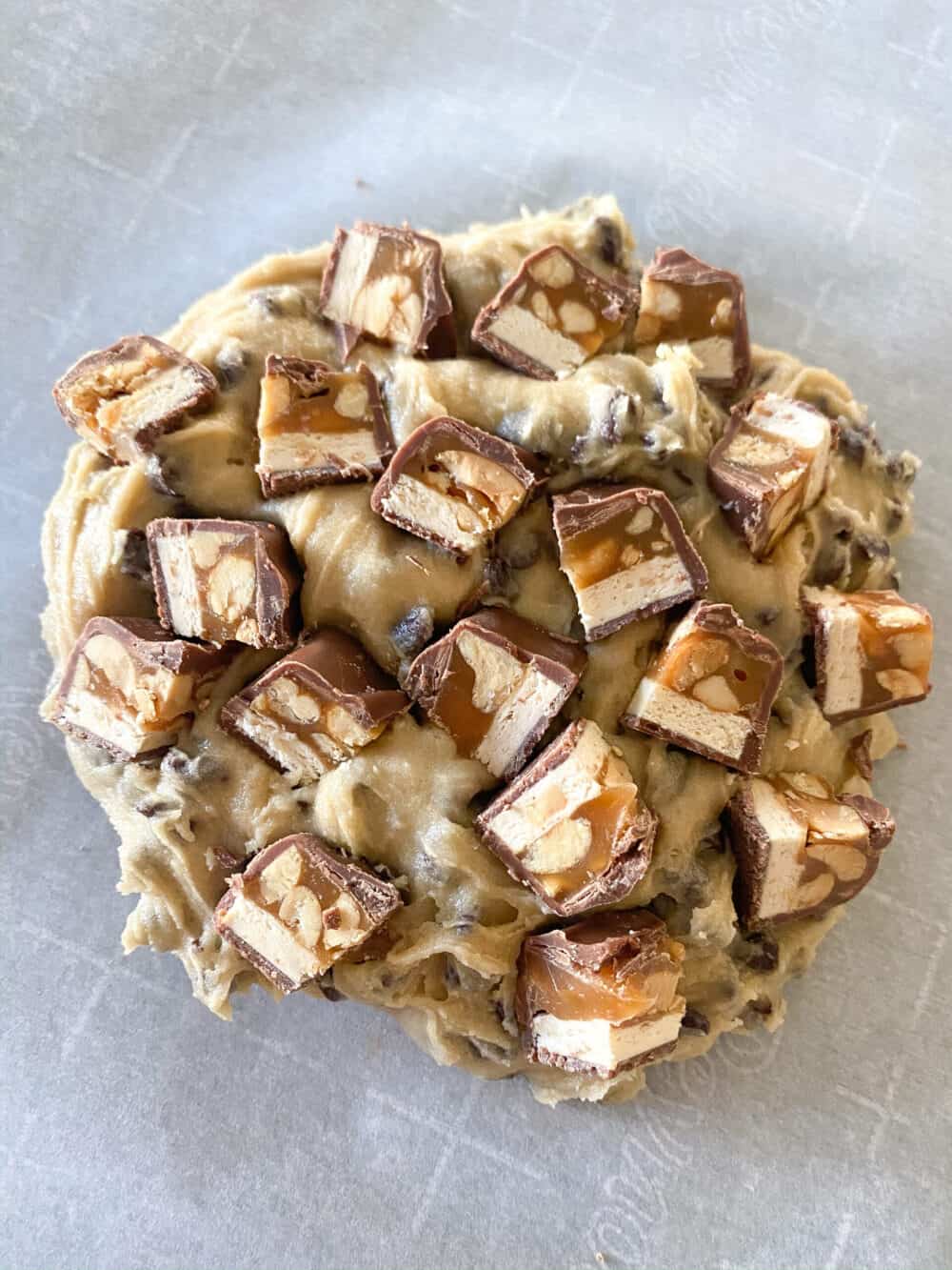 add cubed snickers bar pieces to top of hot cookie