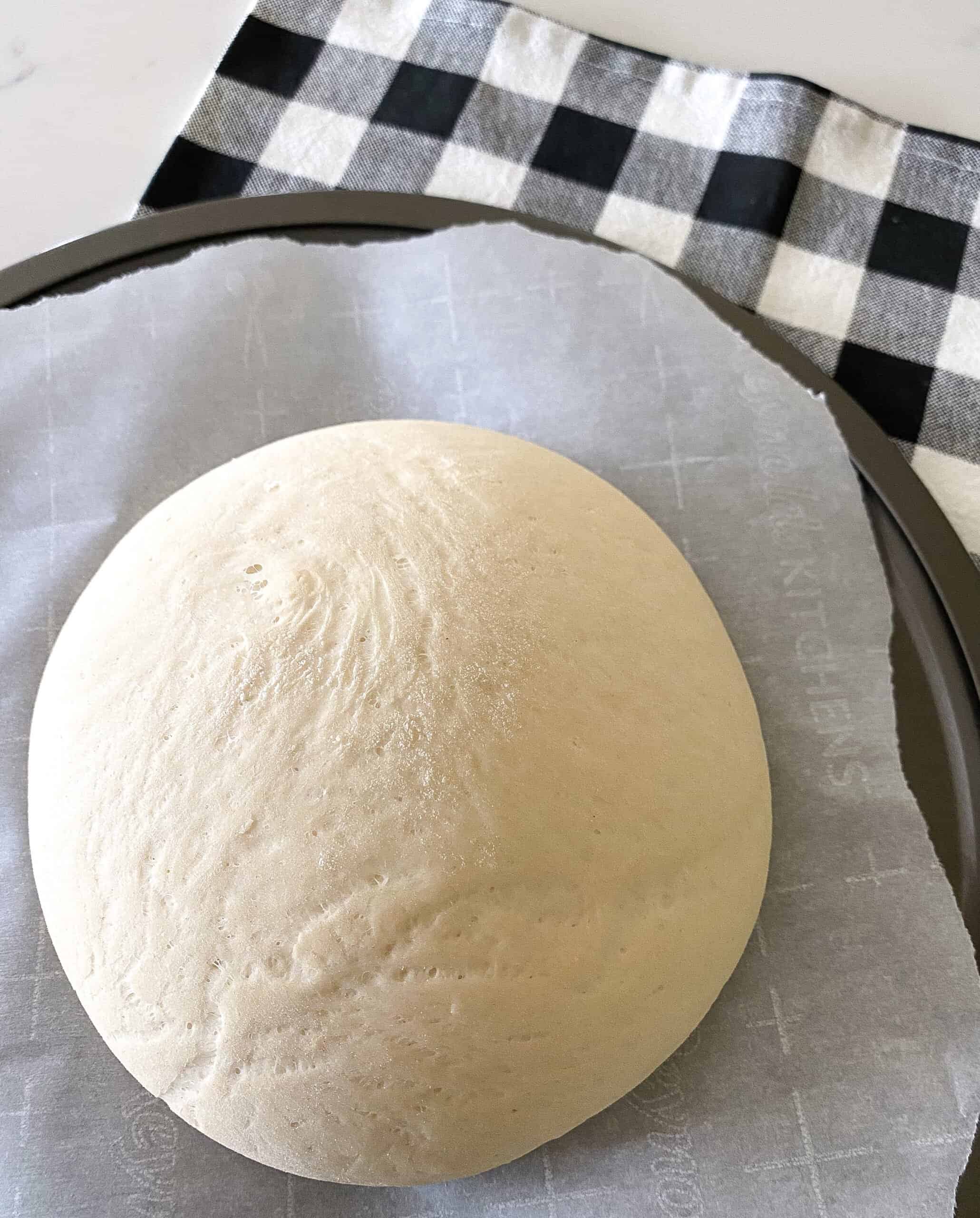 pizza dough round on baking sheet