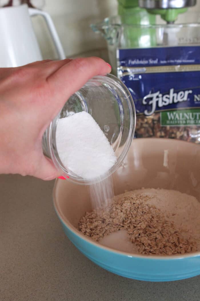 pouring sugar in bowl of dry ingredients for homemade pancakes
