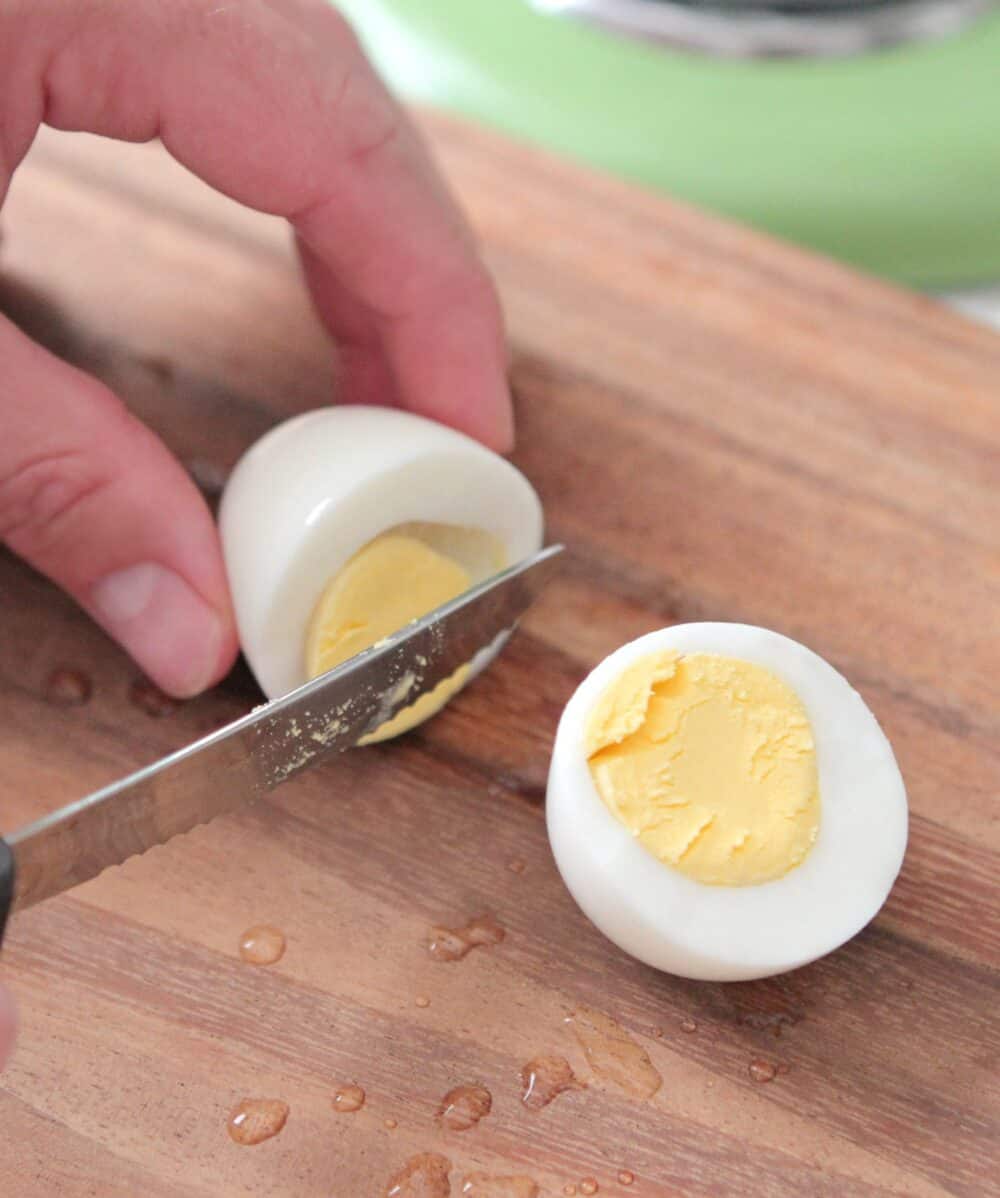 Hand cutting a hard boiled egg to see inside