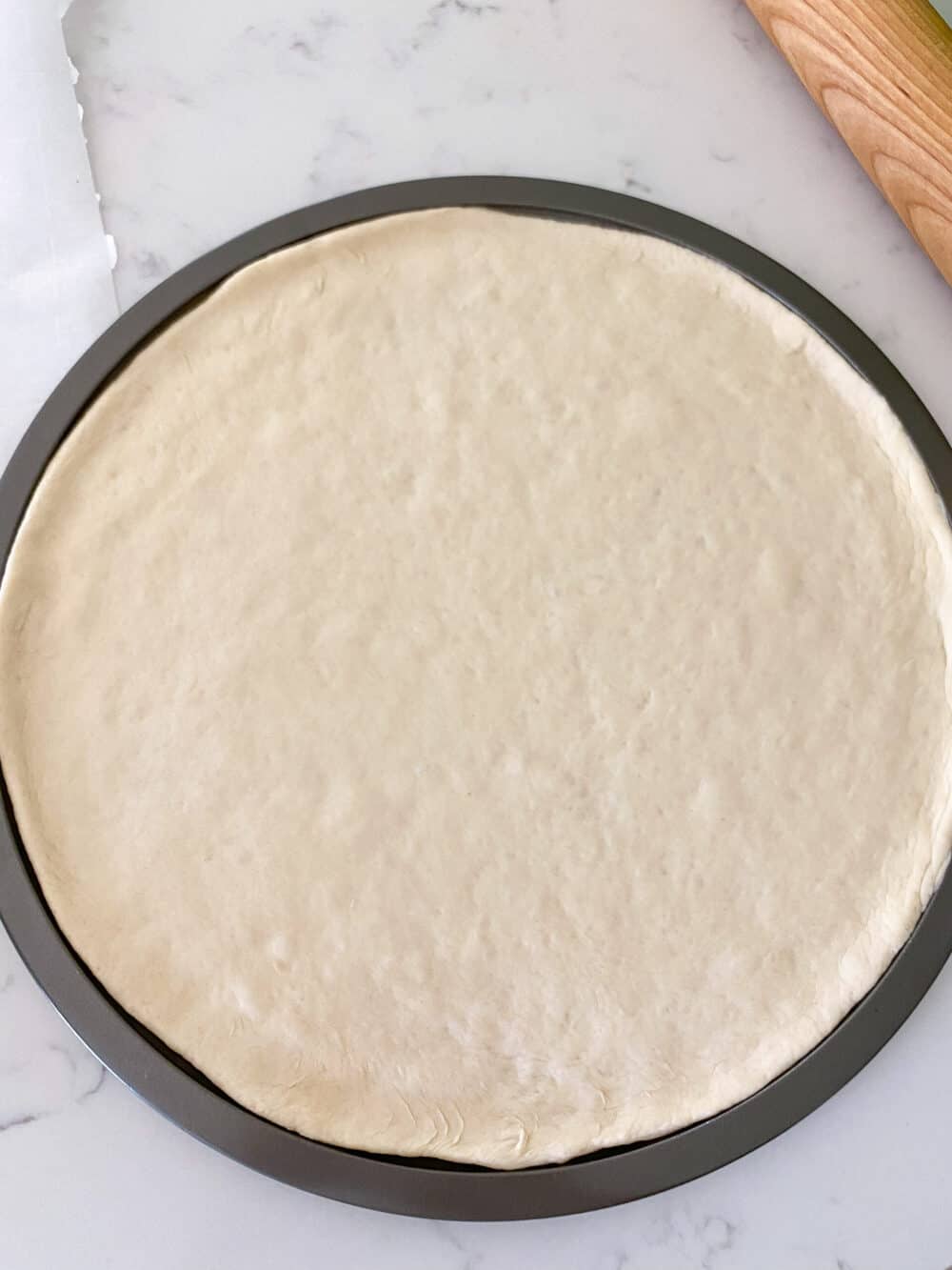 pizza dough on pizza pans ready to bake