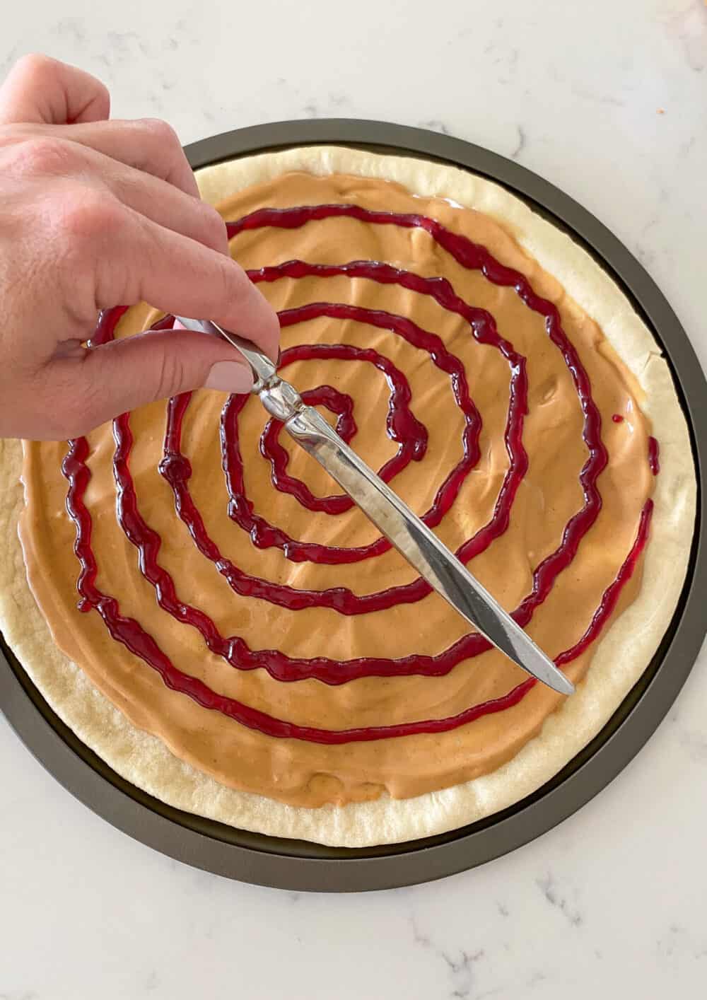 swirling jelly into peanut butter