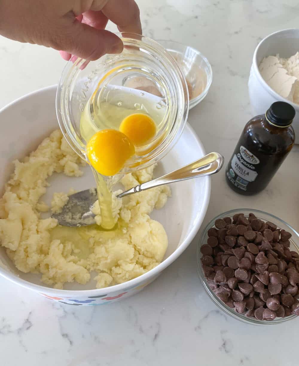 adding eggs to mixing bowl for chocolate chip banana bread