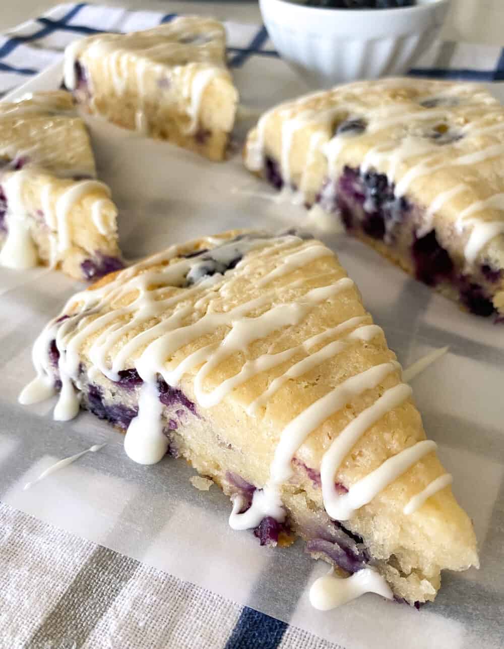 drizzling icing over blueberry scones