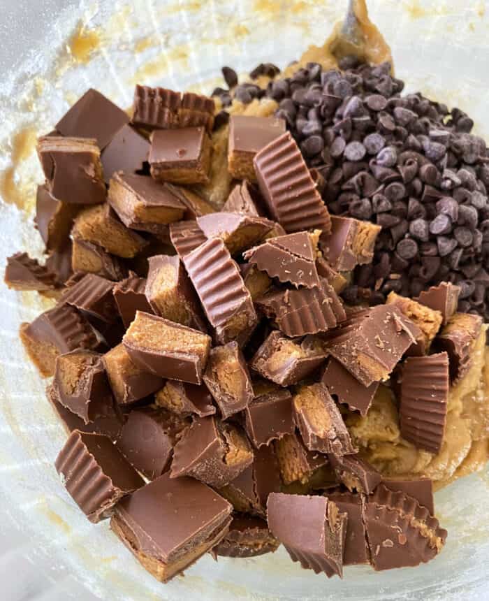 peanut butter cups and chocolate chips added to mixing bowl