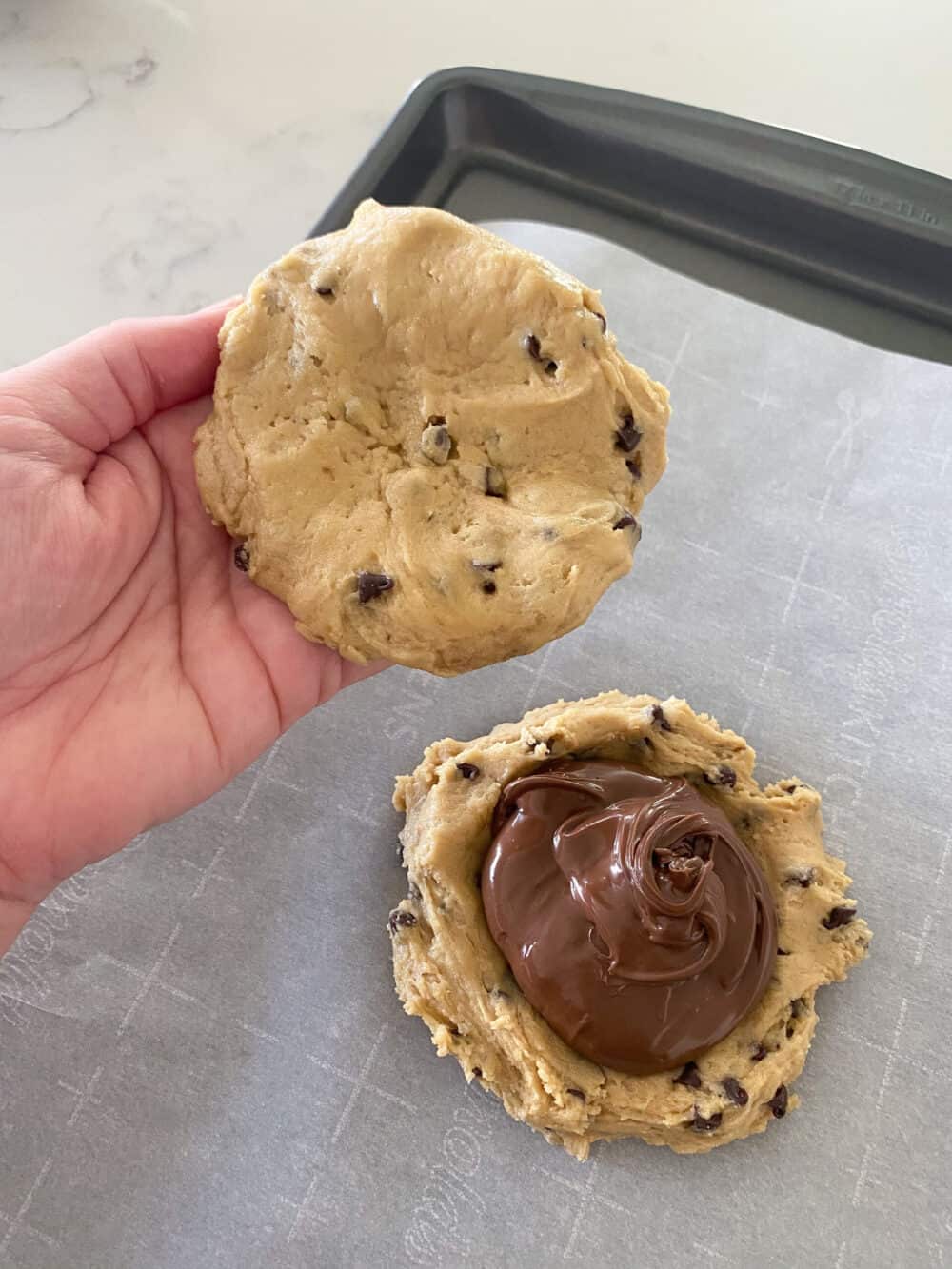 cookie dough pressed over Nutella layer between bottom cookie dough