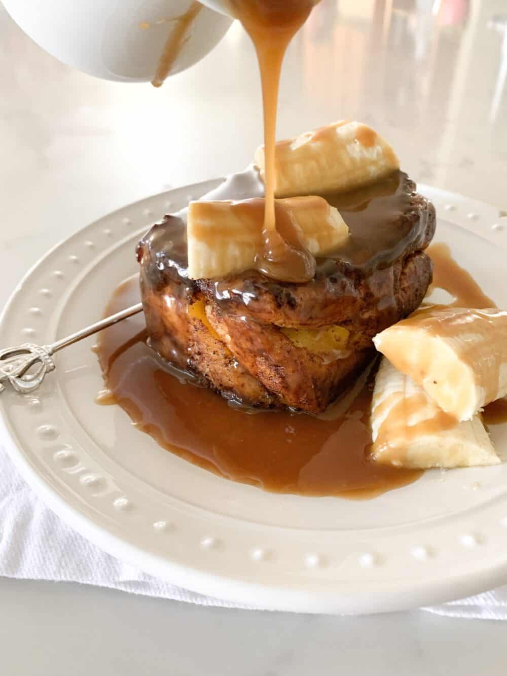 pouring caramel over brioche french toast
