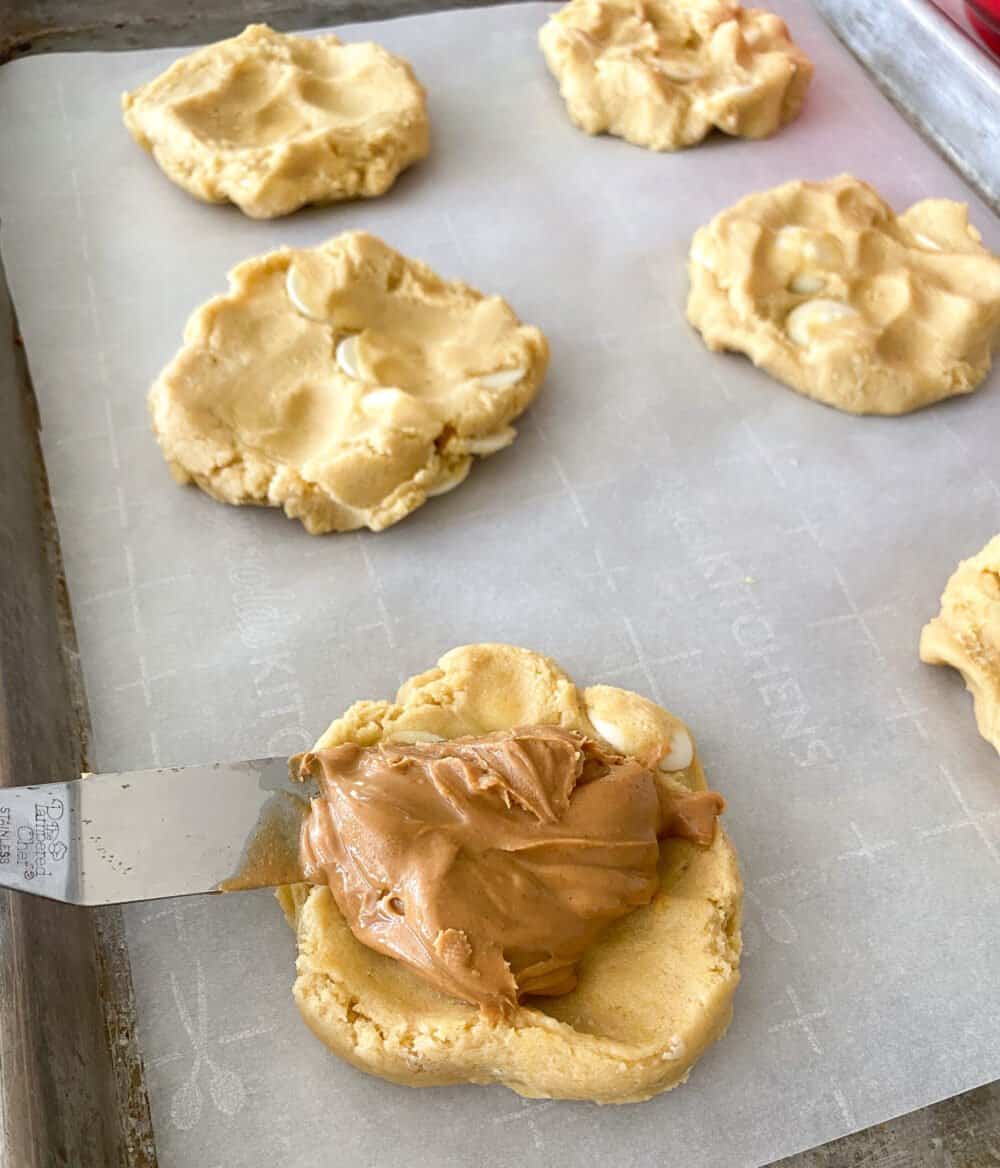 peanut butter and jelly stuffed cookie dough on baking sheet