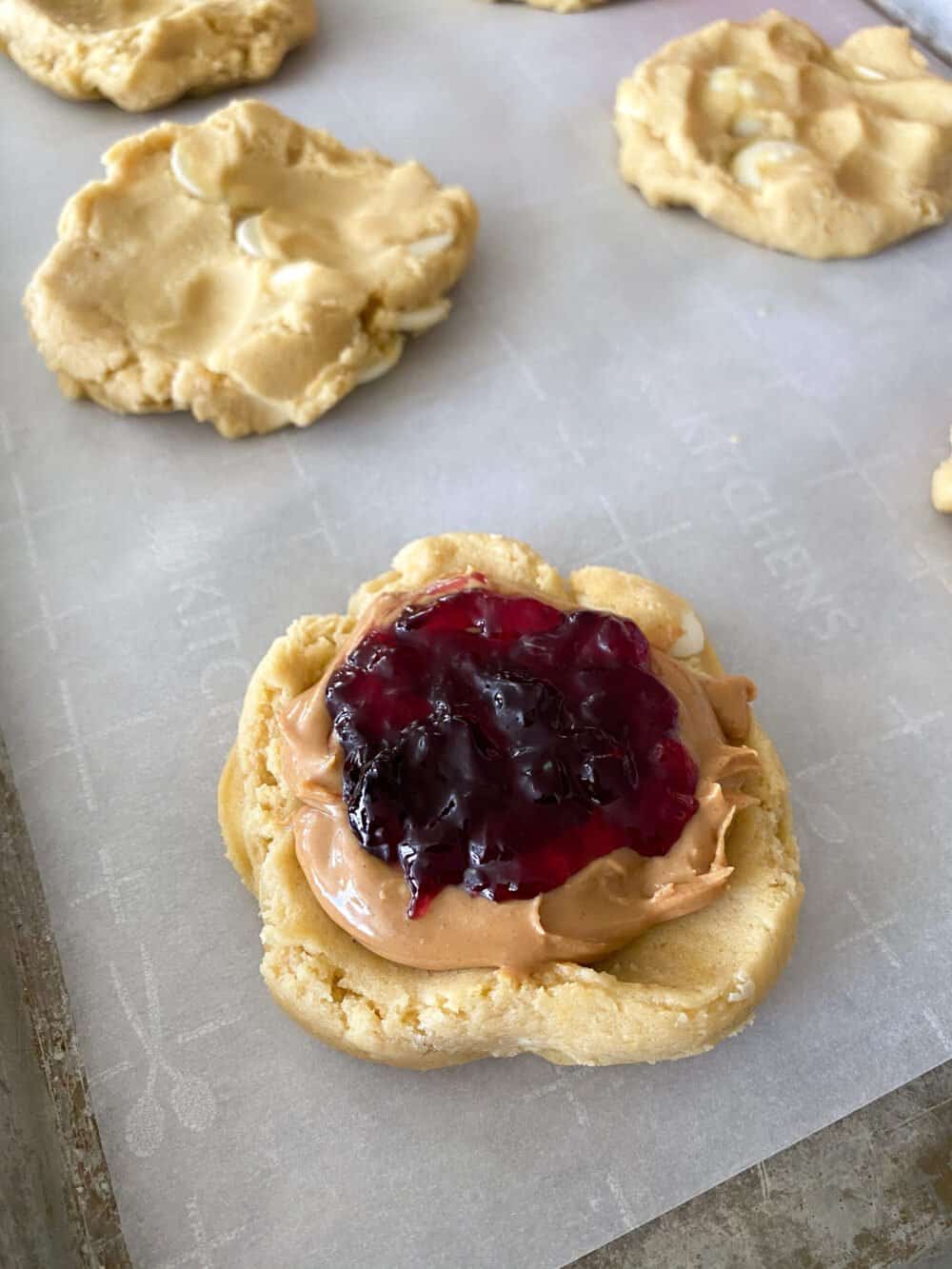 adding peanut butter and jelly to center of cookie dough
