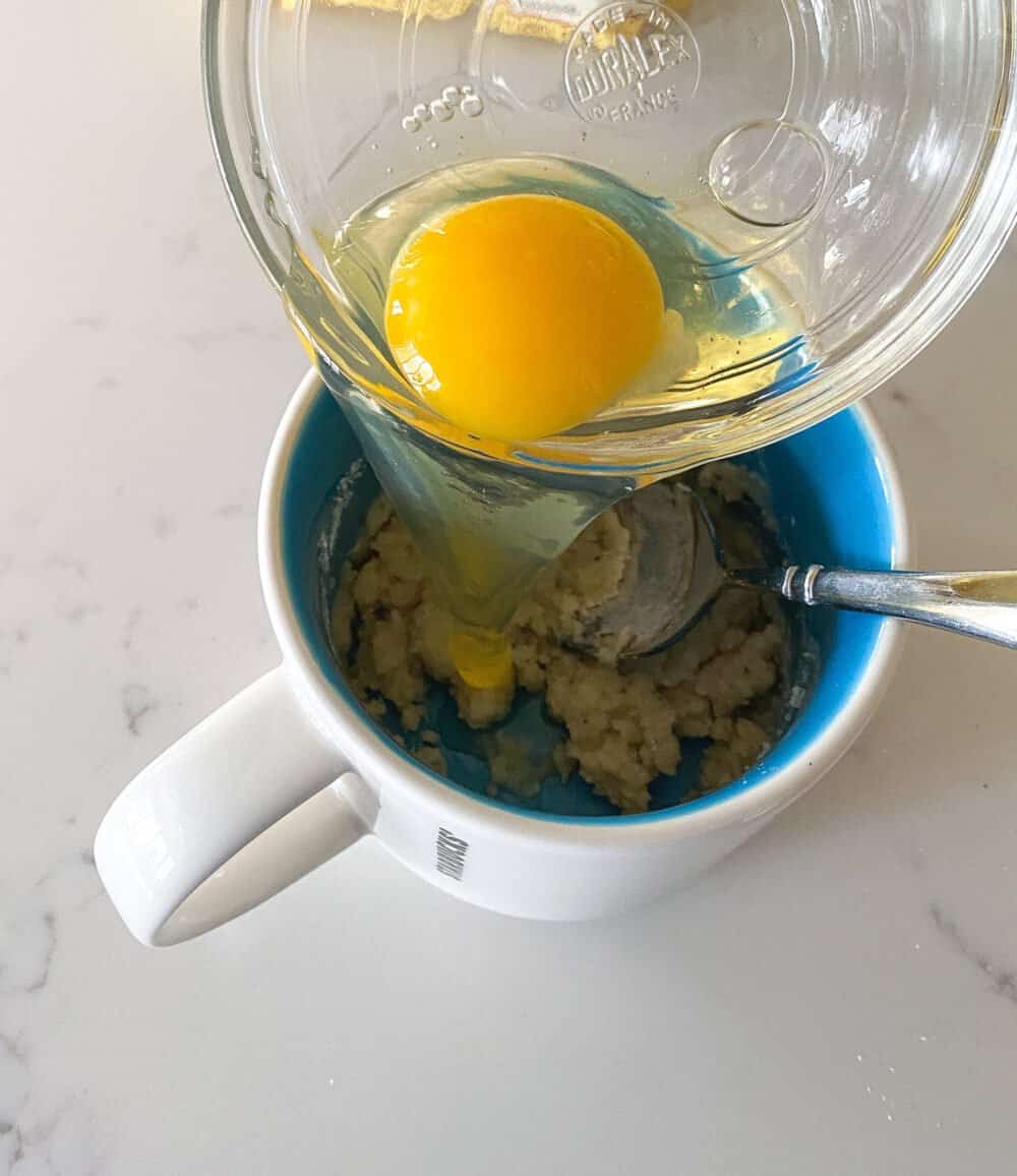 adding egg to mug