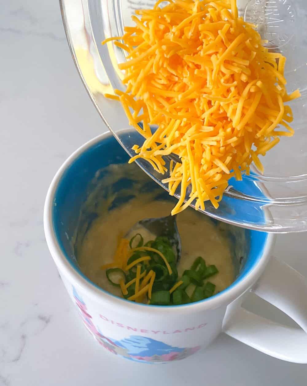 adding cheese to mug
