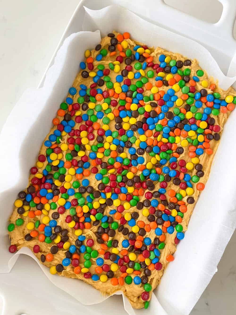 m&m's over cookie dough in baking dish