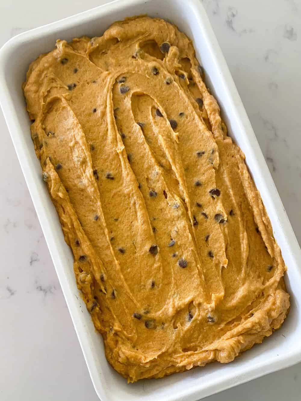 pumpkin chocolate chip bread batter into loaf pan