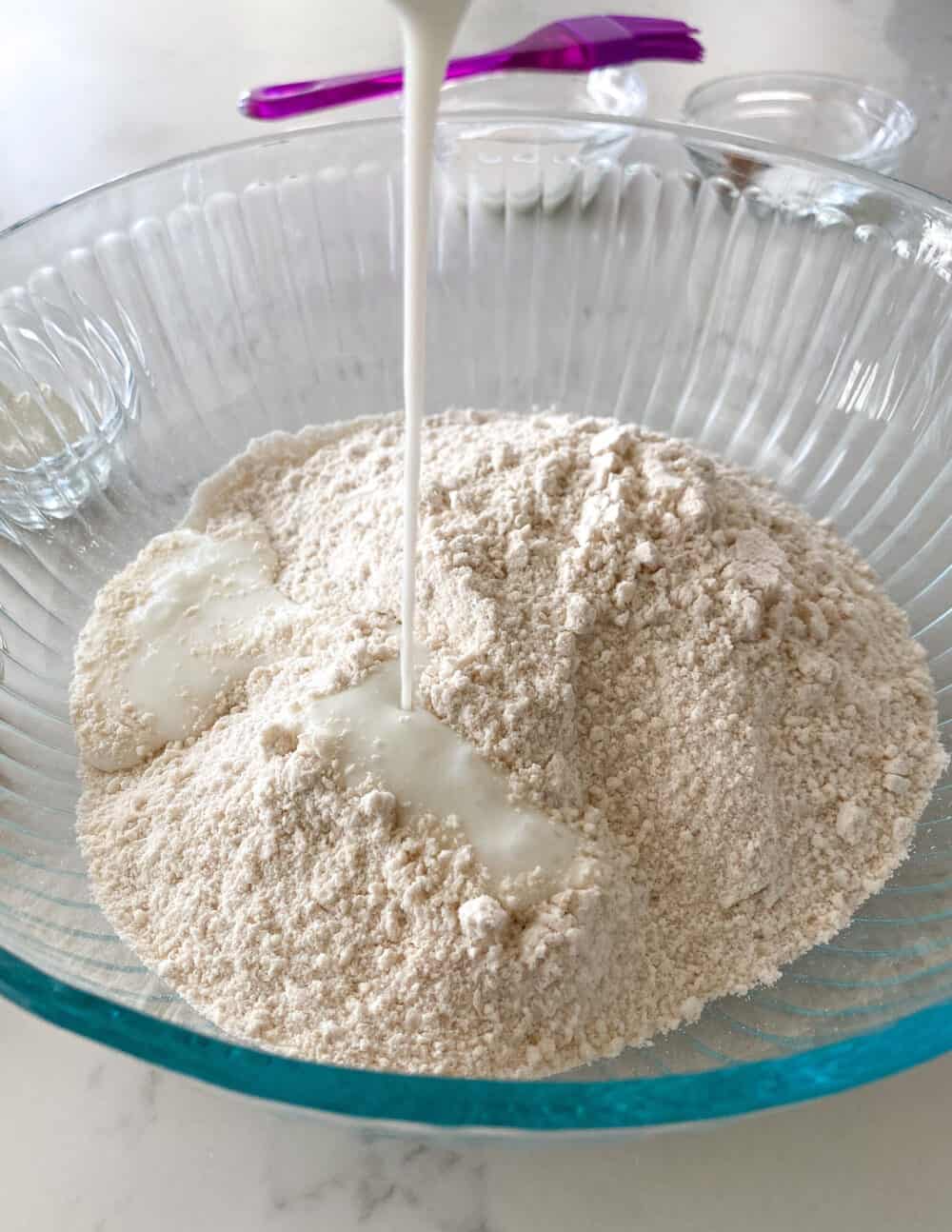 adding buttermilk to mixing bowl of pumpkin scones