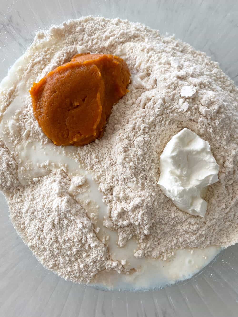 pumpkin added to mixing bowl of pumpkin scones