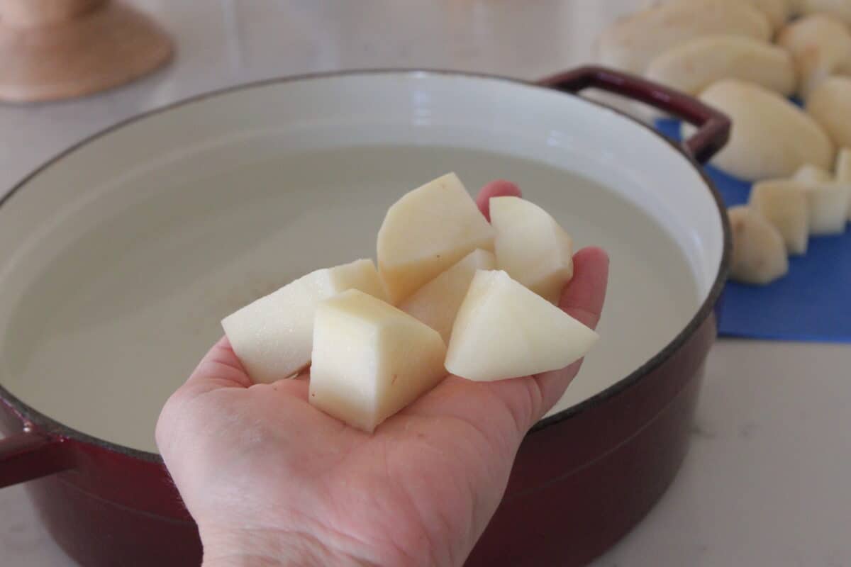 cubed potatoes going into pot of water