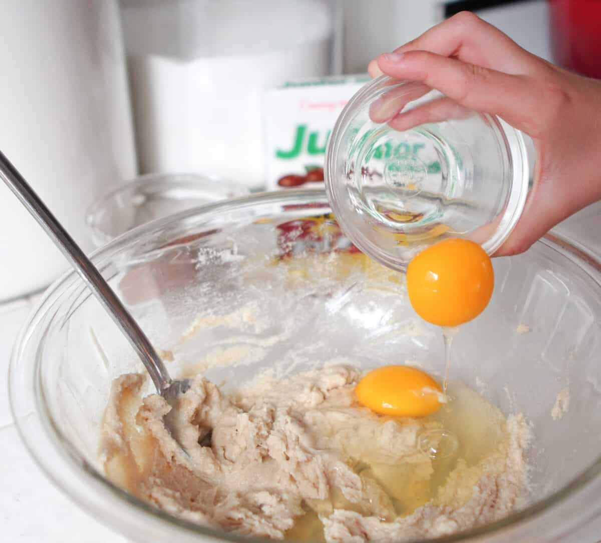 adding eggs to mixing bowl of creamed butter and sugar