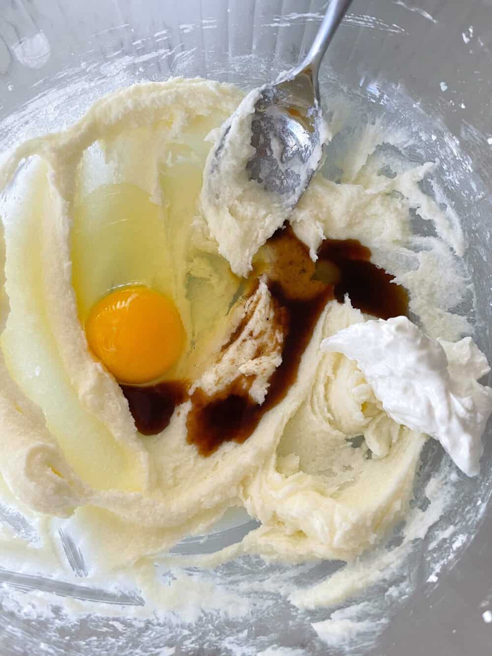 adding eggs and vanilla to mixing bowl