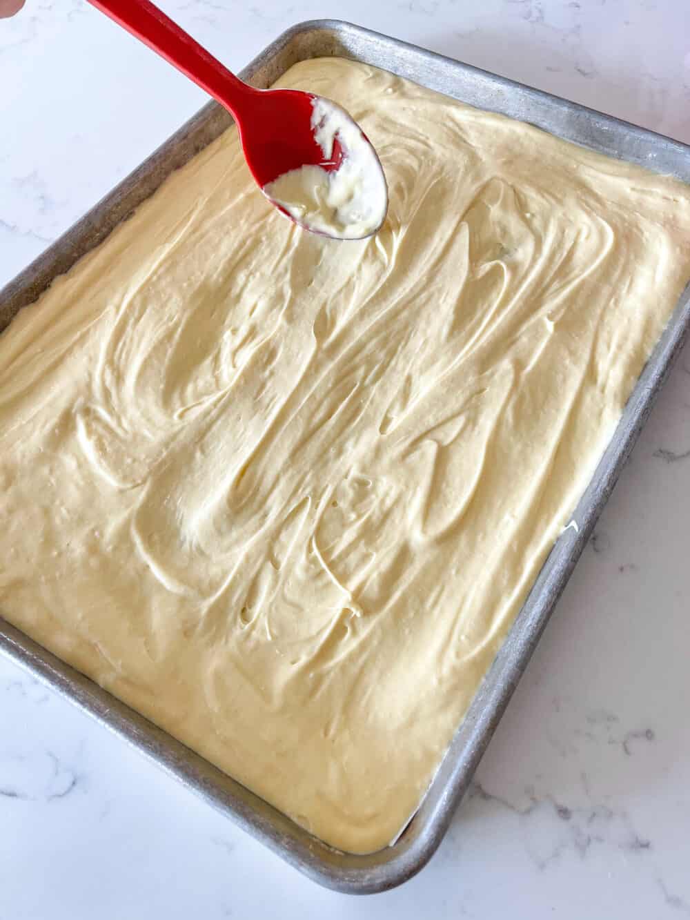 spreading cake batter into half sheet pan