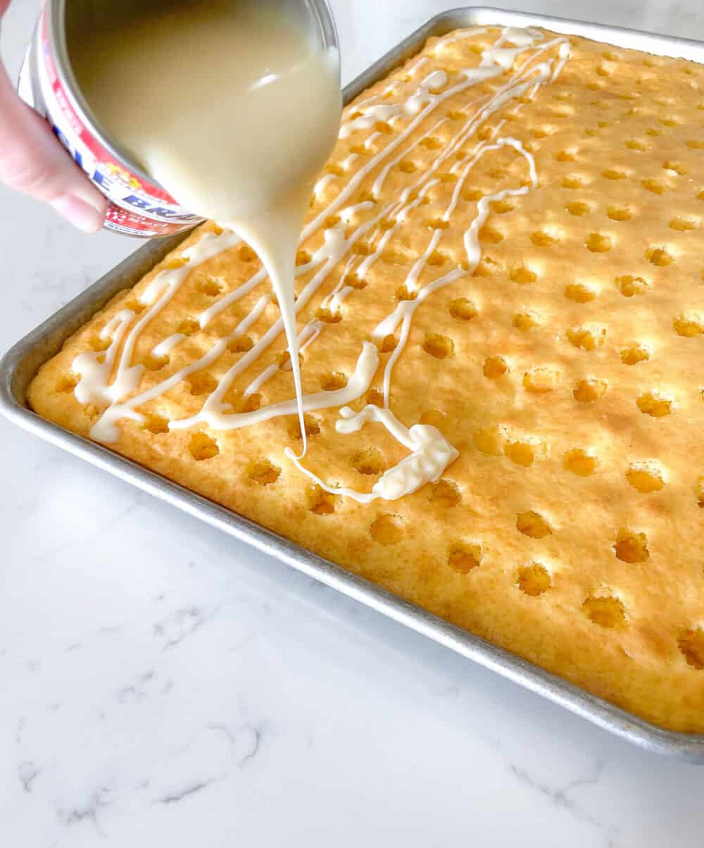 drizzling sweetened condensed milk over sheet cake
